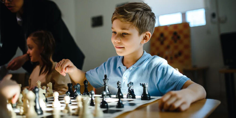 A young student concentrating on a chess board